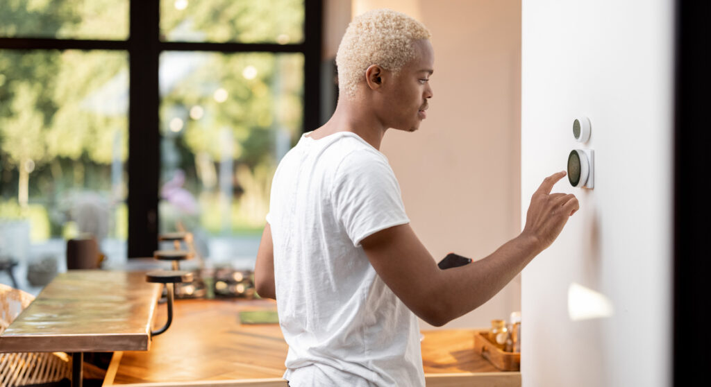 HVAC technician installing smart thermostat in modern home